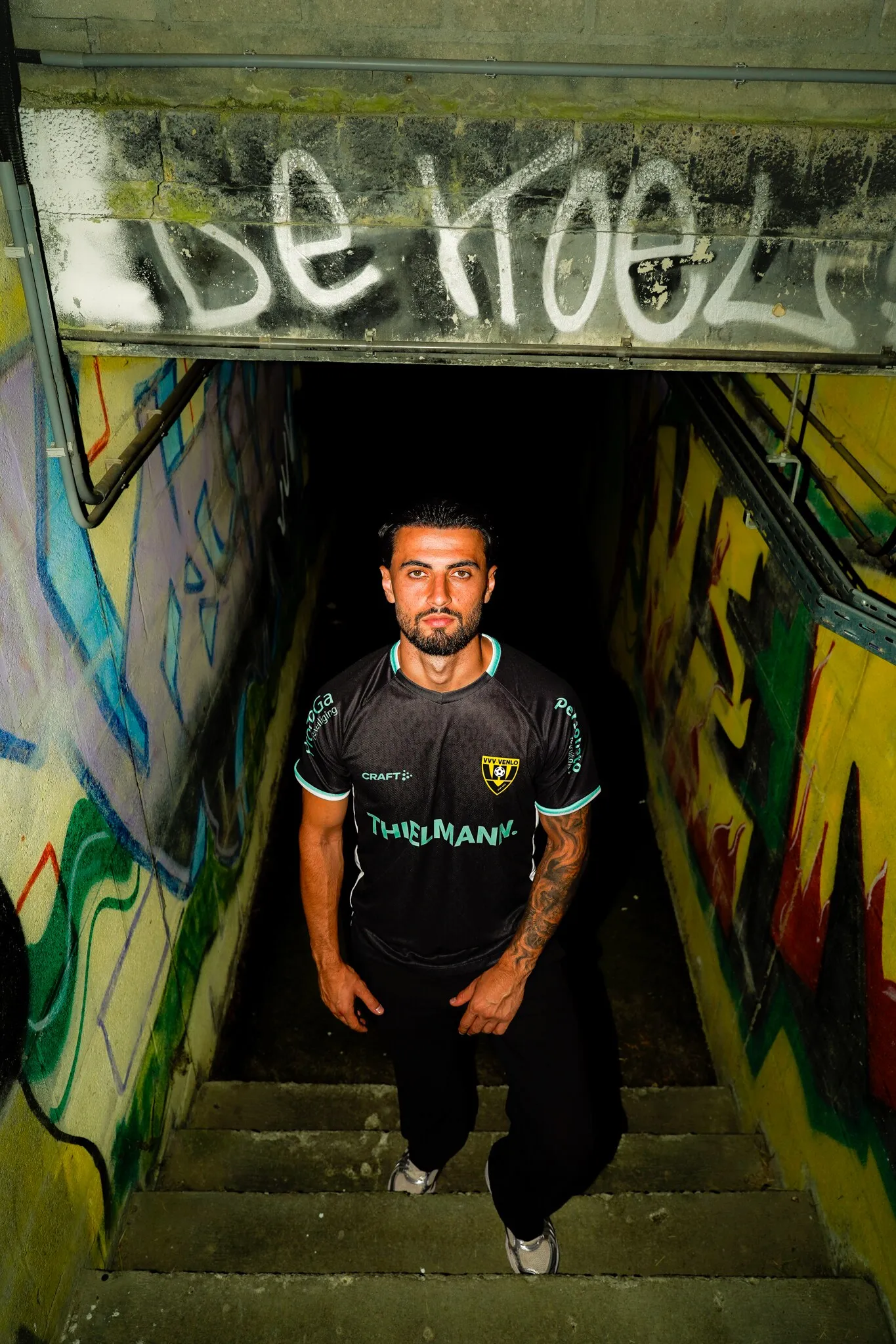 Voetballer van VVV-Venlo poseert in een met graffiti beschilderde tunnel